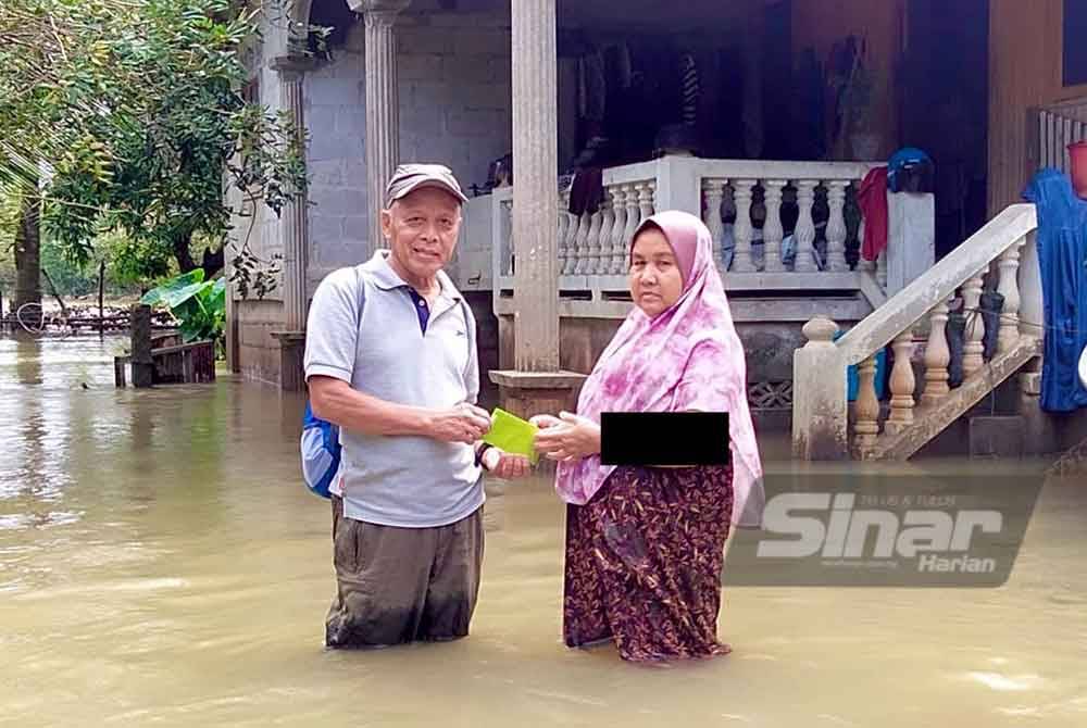 Penduduk menerima agihan bantuan daripada MySinar yang diagihkan oleh Muhammad Nasir (kiri). Foto SINAR HARIAN