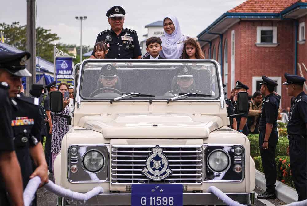 Aidi (kiri) mengucapkan selamat tinggal kepada pasukan PDRM selepas menabur bakti selama 36 tahun, susulan persaraan wajibnya Januari ini. - Foto Bernama