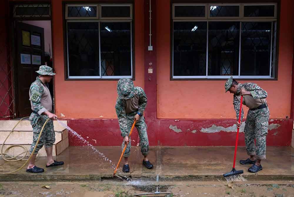 Gotong-royong membersihkan sekolah dilakukan bagi memastikan murid-murid meneruskan sesi persekolahan bagi penggal ketiga yang akan bermula pada 2 Januari depan, berjalan dengan lancar. - Foto: Bernama
