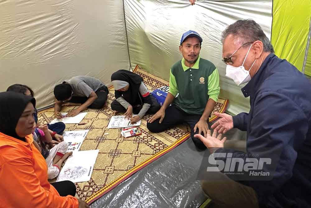Dr Dzulkefly (kanan) melawat mangsa banjir yang ditempatkan di PPS SK Jeli.