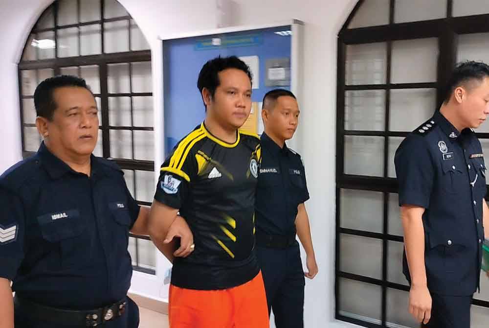 Said Afendi (tengah) di bawa ke Mahkamah Majistret Johor Bahru pada Ahad.