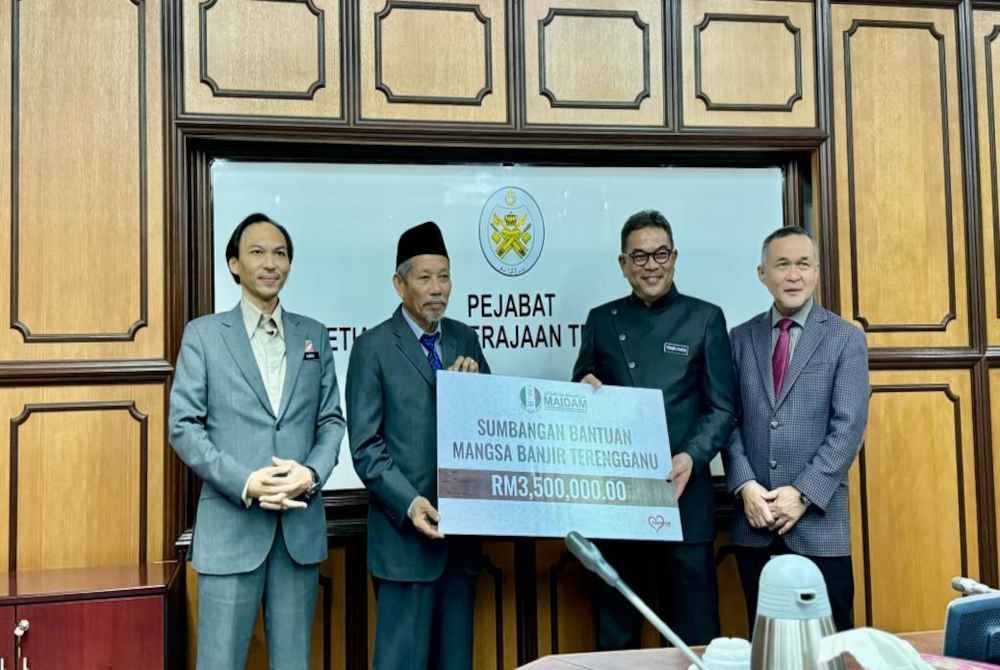 Shaikh Harun (dua dari kiri) menyampaikan bantuan banjir berjumlah RM3.5 juta kepada Tengku Farok Hussin (dua dari kanan).