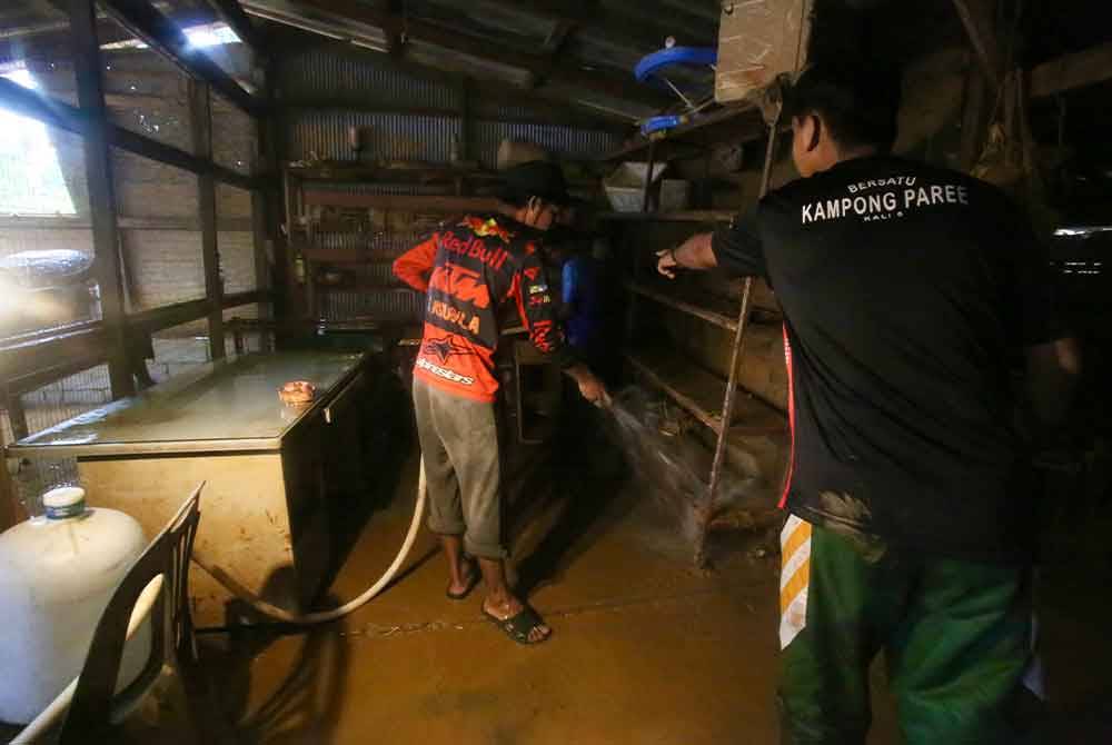 Lumpur tebal menyukarkan kerja-kerja membersihkan rumah. - Foto Bernama