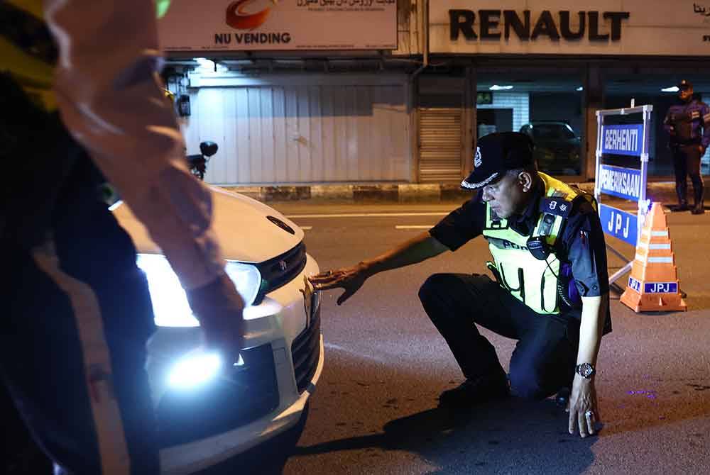 Shuhaimi melakukan pemeriksaan kenderaan pada Operasi Ambang Tahun Baharu di sekitar Kota Bharu malam tadi. - Foto Bernama