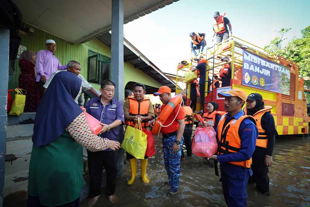 Sukarelawan Pertubuhan Kebajikan MCIO bersama Pejabat Pembangunan Negeri Kelantan, ICU JPM dan APM dibantu penduduk kampung mengagihkan bekalan makanan serta menyantuni kira-kira 50 mangsa daripada 11 keluarga di Kampung Bongor semalam. - Foto Bernama