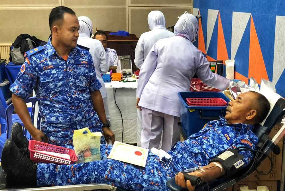 Zairil Anuar (kiri) beramah mesra bersama anggota APM yang menyertai program derma darah di Pejabat APM Daerah Kota Setar di sini pada Isnin.