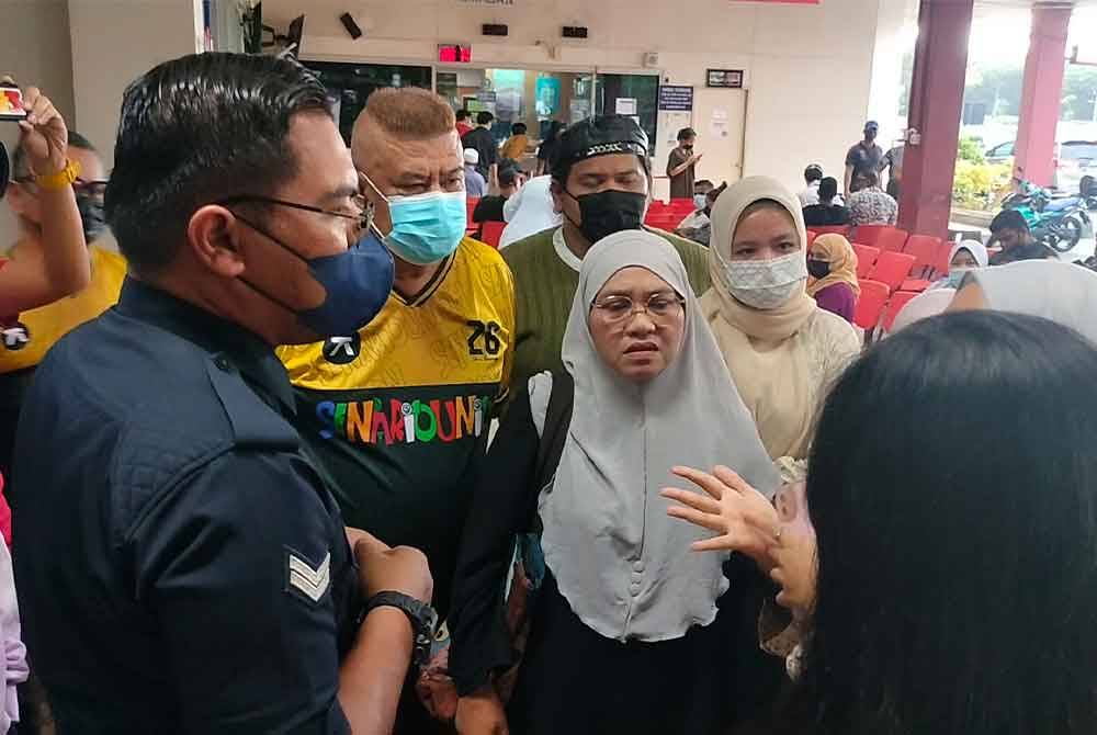 Ahli keluarga dan Azlee di pekarangan HSA Johor Bahru berbincang mengenai keadaan Hamdan.