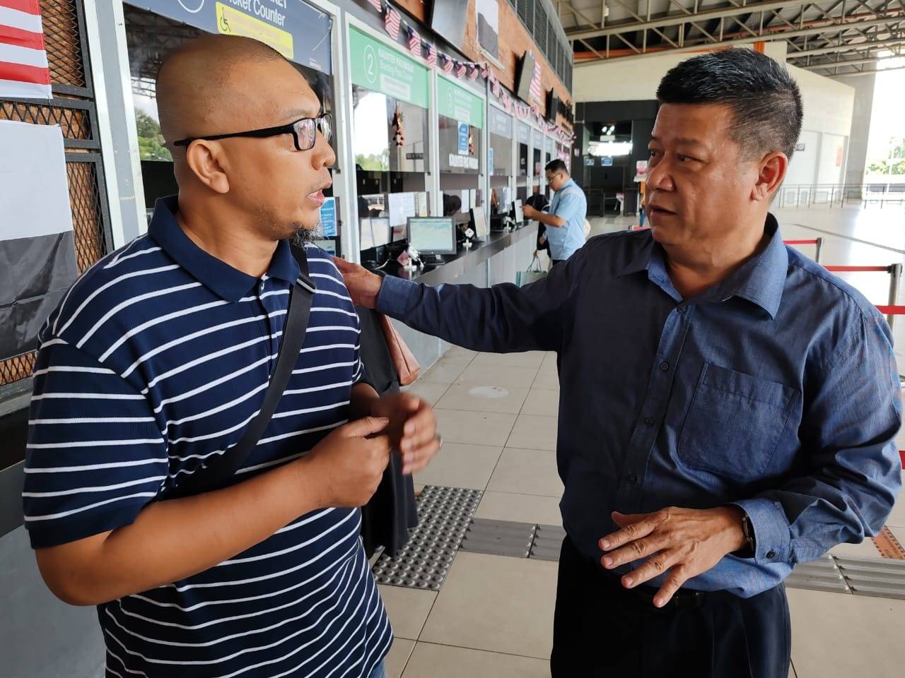 Pengurus TSK, Khairul Amilin Abdul Halil (kiri) memaklumkan sesuatu kepada Chon Siang ketika sesi pemantauan di terminal terbabit pada Isnin.