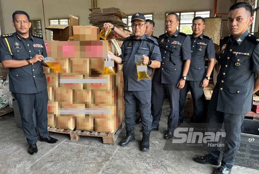 Azman (empat dari kanan) menunjukkan rampasan minyak masak peket yang dilakukan oleh KPDN Kelantan sebelum ini.
