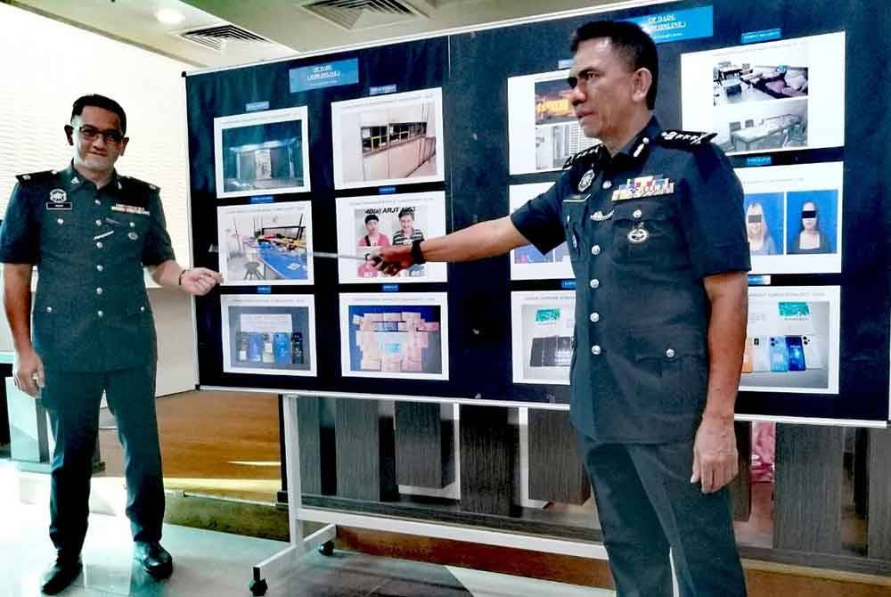 Fisol (kanan) menunjukkan modus operandi judi dalam talian yang beroperasi dari sebuah premis di Sungai Kob, Kulim.