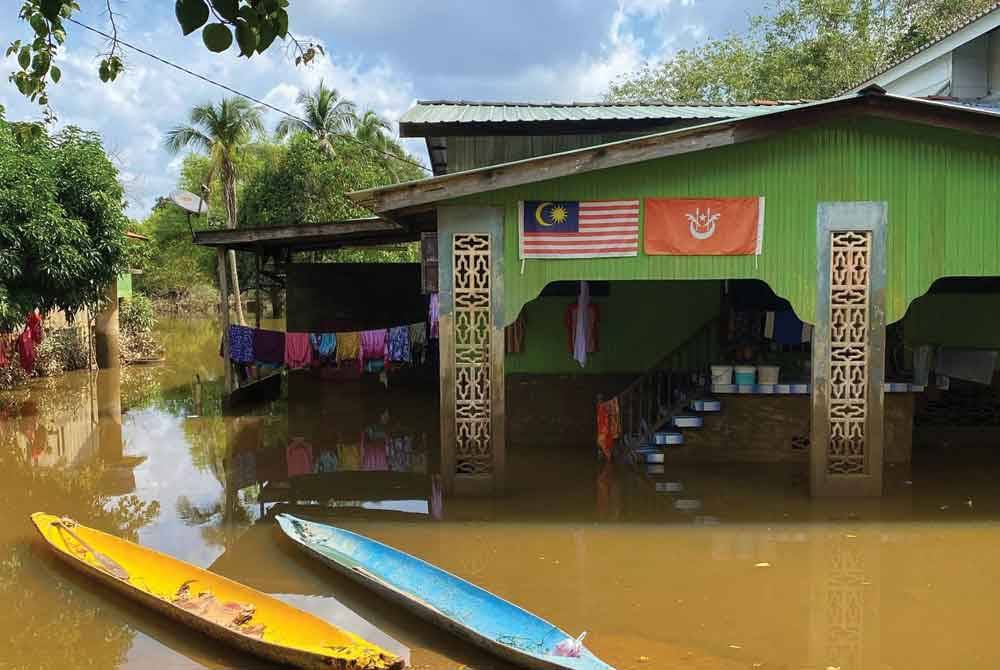 Kelihatan penduduk masih menggunakan perahu di Kampung Tersang, Rantau Panjang yang terkesan dengan banjir termenung.