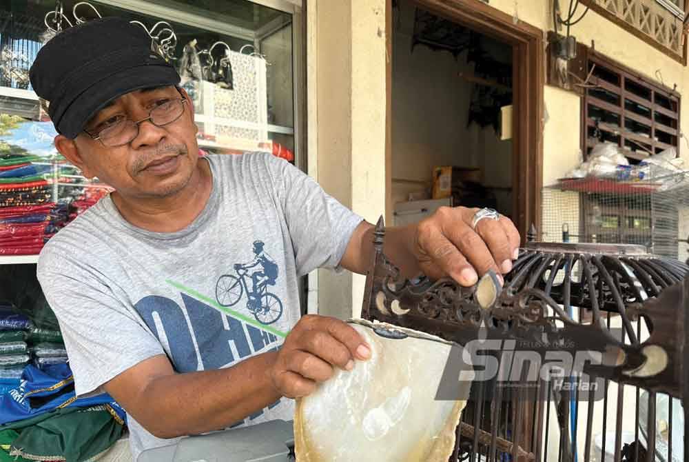 Che Roslan menunjukkan kulit tiram yang digunakan untuk mencantikkan lagi sangkar burung. Foto Sinar Harian-ADILA SHARINNI WAHID