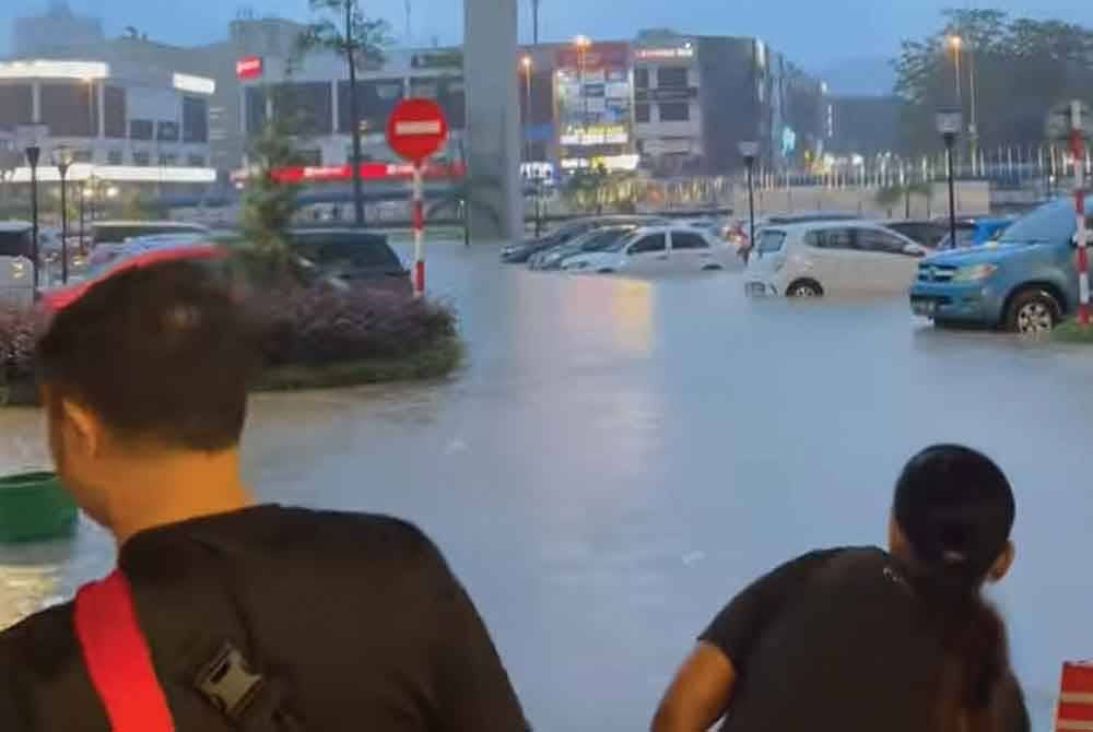 Pengunjung melihat kenderaan-kenderaan di luar pusat beli-belah IOI Mall Puchong yang ditenggelami banjir kilat pada 16 Disember lalu.