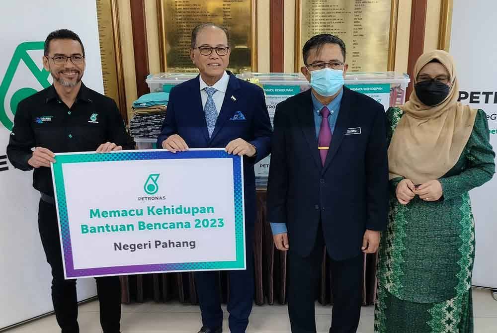 Mohammad Ahmad Shazly (kiri) menyerahkan sumbangan Pakej Prihatin berupa 1,500 pek barang keperluan kepada Wan Rosdy (dua dari kiri) untuk disalurkan kepada mangsa banjir di negeri ini.