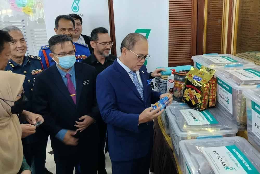 Wan Rosdy meninjau pek barang keperluan sumbangan Yayasan Petronas bagi membantu mangsa banjir di negeri ini.