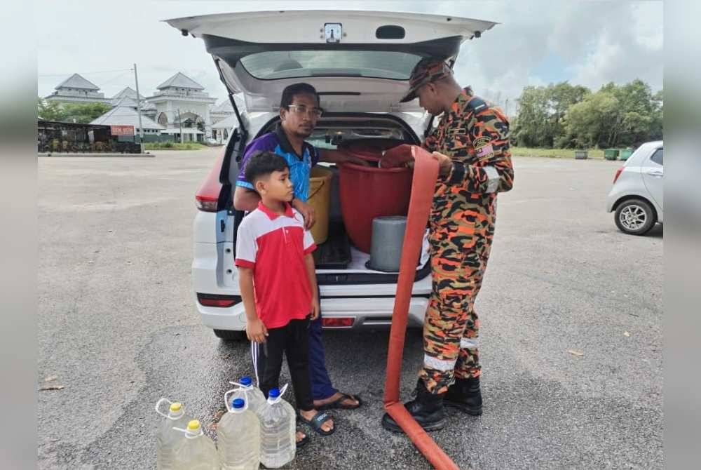 Penduduk yang terjejas menadah air untuk kegunaan harian di kawasan yang disediakan oleh JBPM di dataran Limbungan, Dewan Undangan Negeri (DUN) Kota Putera, Besut.