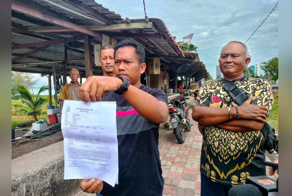
Mohd Muszairi (tengah) menunjukkan laporan polis yang dibuat akibat kerugian yang dialami mencecah RM8,000.