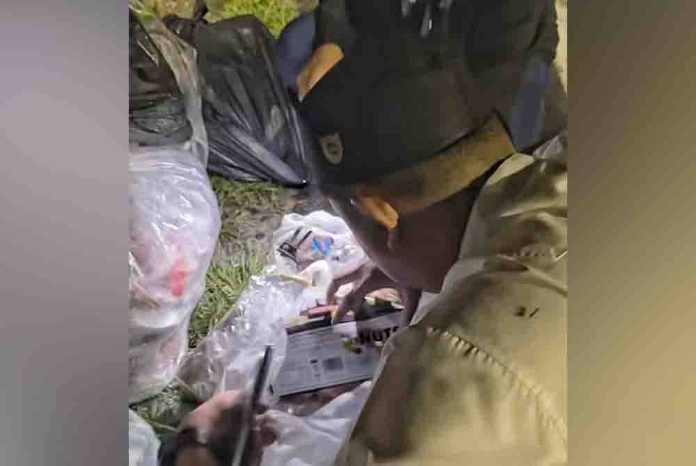 Akmal selongkar plastik sampah untuk mencari maklumat individu yang membuang sampah di kawasan itu.