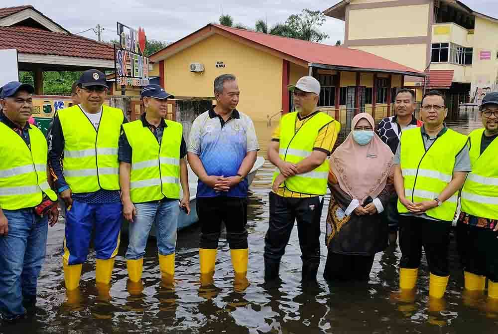 Shafruddin (lima dari kanan) dan Razali (lima.dari kanan) bersama.pihak sekolah serta sukarelawan KPM meninjau keadaan
SK Temai yang masih digenangi air sedalam.0.48 meter pada Khamis.