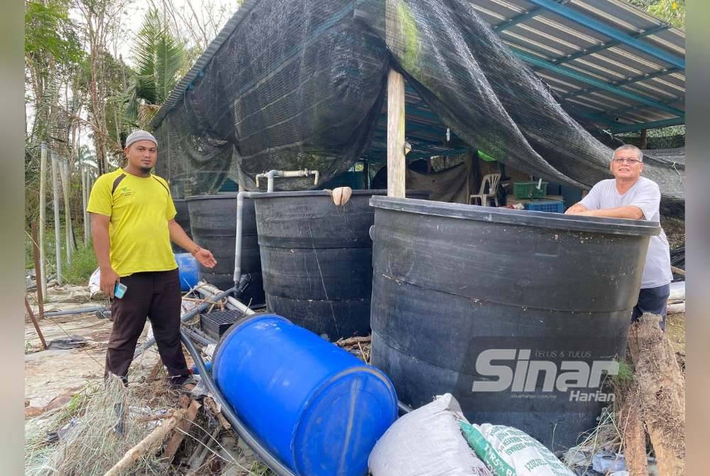 Mohd Nor Hafiz (kiri) mendakwa sejak pembinaan benteng kawasan kebunnya ditenggelami air lebih 0.7 meter.