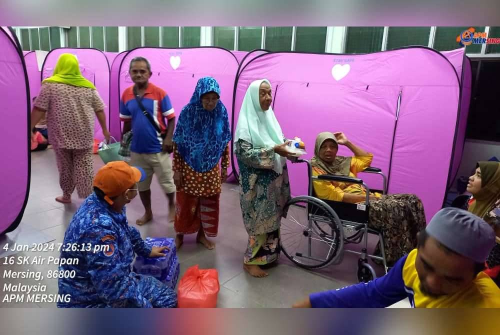Anggota Pertahanan Awam Malaysia meninjau keadaan mangsa banjir di PPS di Dewan Kampung Sungai Tiram, Ulu Tiram, Johor Bahru pada Khamis. Foto APM Johor