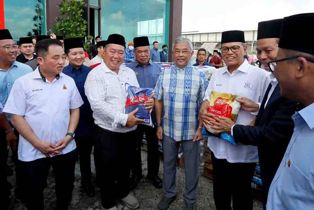 Al-Sultan Abdullah (depan, tiga dari kiri) berkenan mewakili kerajaan Pahang menerima sumbangan beras sebanyak 10 tan metrik untuk diagihkan kepada mangsa banjir di negeri itu.