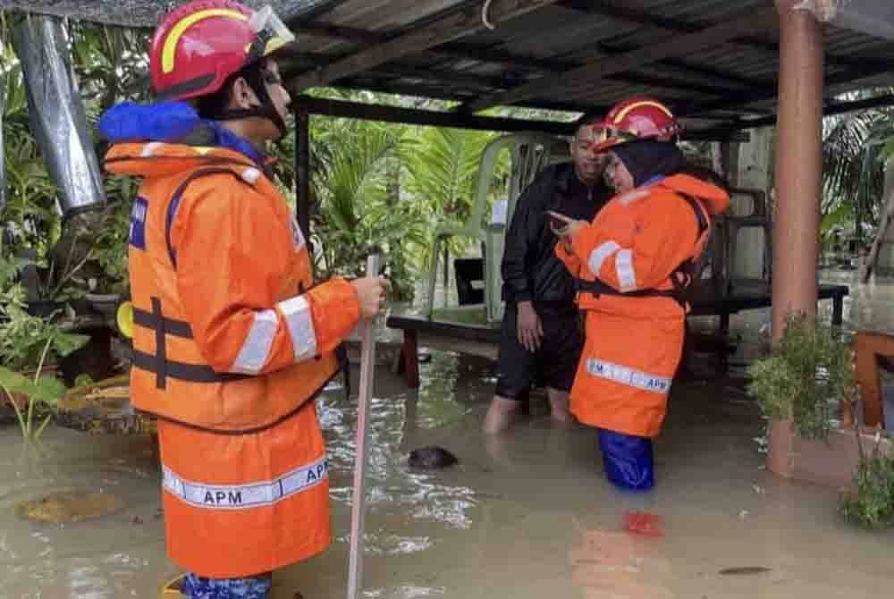 Anggota Pertahanan Awam Malaysia meninjau keadaan di sebuah kampung di Mersing yang dinaiki air sejak Khamis. - Foto: APM Johor