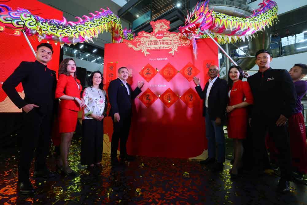 Anthony (empat dari kiri) menunjukkan harga tambang murah AirAsia ke Sabah dan Sarawak sempena Tahun Baharu Cina. - Foto Bernama