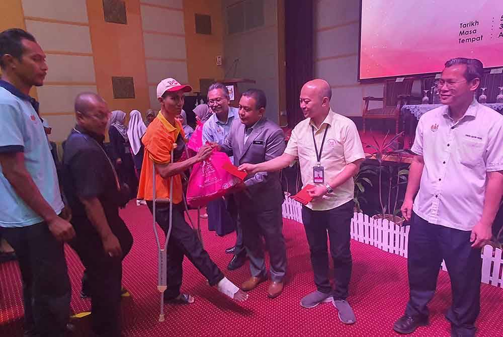 Sui Hau menyampaikan bantuan kepada salah seorang petugas MBSP dalam program tautan jasih One Hope Charity 2023, pada Jumaat.