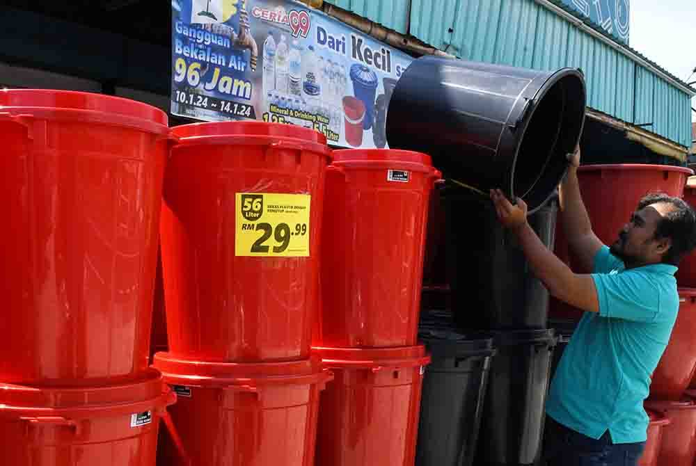 Amin Jafni Abdullah memilih tong air di sebuah pasar Raya di Teluk Kumbar sebagai persiapan susulan gangguan bekalan air berjadual selama empat hari bermula 10 Januari hingga 14 Januari ini. Foto Bernama