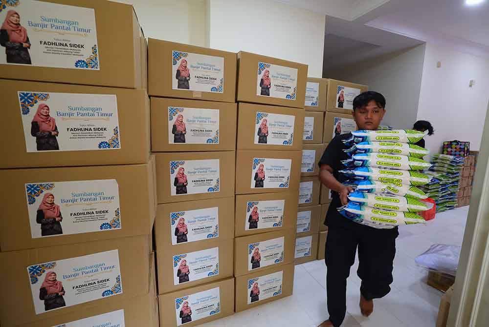 Petugas sukarelawan mengangkat barangan keperluan pada majlis pelepasan Konvoi Misi Bantuan Banjir Pantai Timur di Jalan Presint 10, Putrajaya pada Jumaat. Foto Bernama