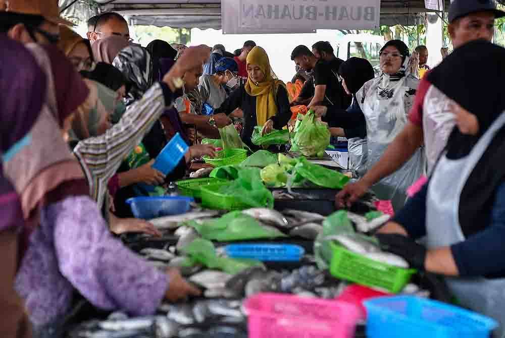 Orang ramai tidak melepaskan peluang beratur untuk membeli barangan keperluan harian pada Jualan Termurah 