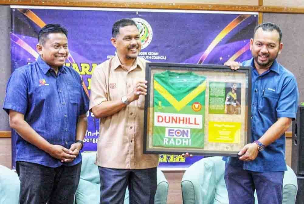 Muhamad Radhi (tengah) menerima cenderahati daripada Presiden Majlis Belia Negeri Kedah, Amir Mursyidi Samsudin pada Sabtu.