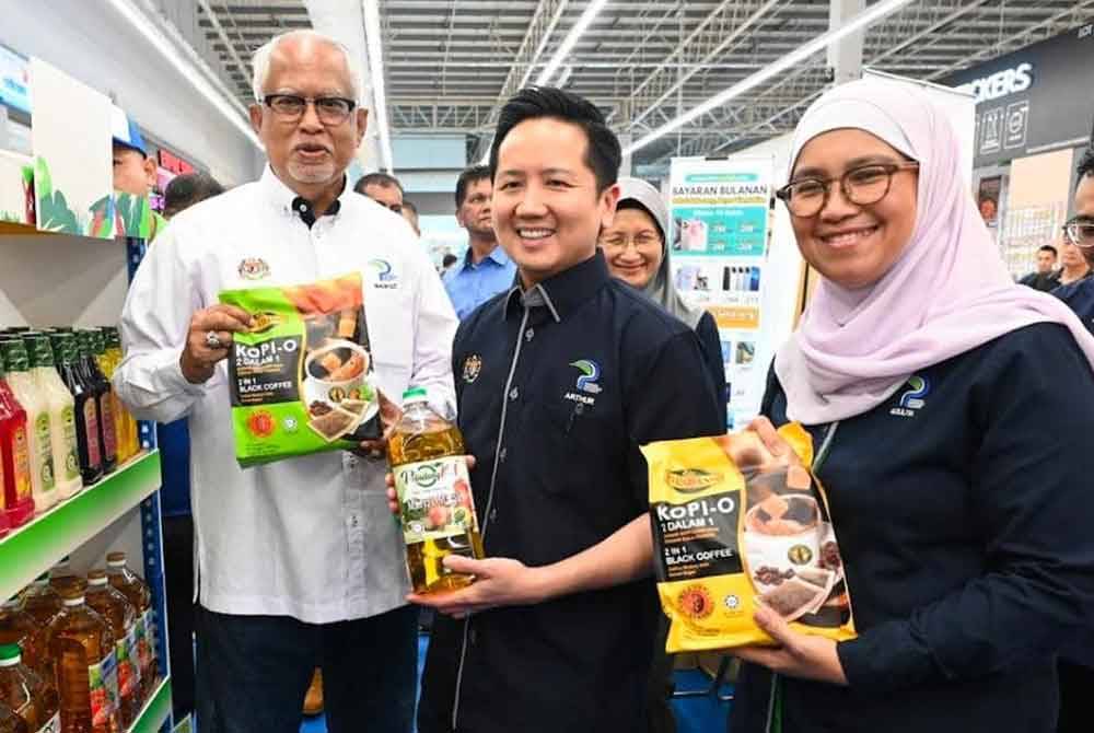 (Dari kiri) Mahfuz dan Arthur bergambar bersama keluaran produk usahawan tempatan. FOTO KPKM