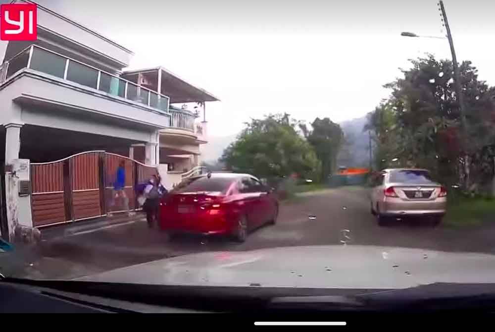 Tangkap layar video dashcam berjaya merakam kelibat dua lelaki keluar daripada pagar rumah mangsa dan melarikan diri di Taiping.