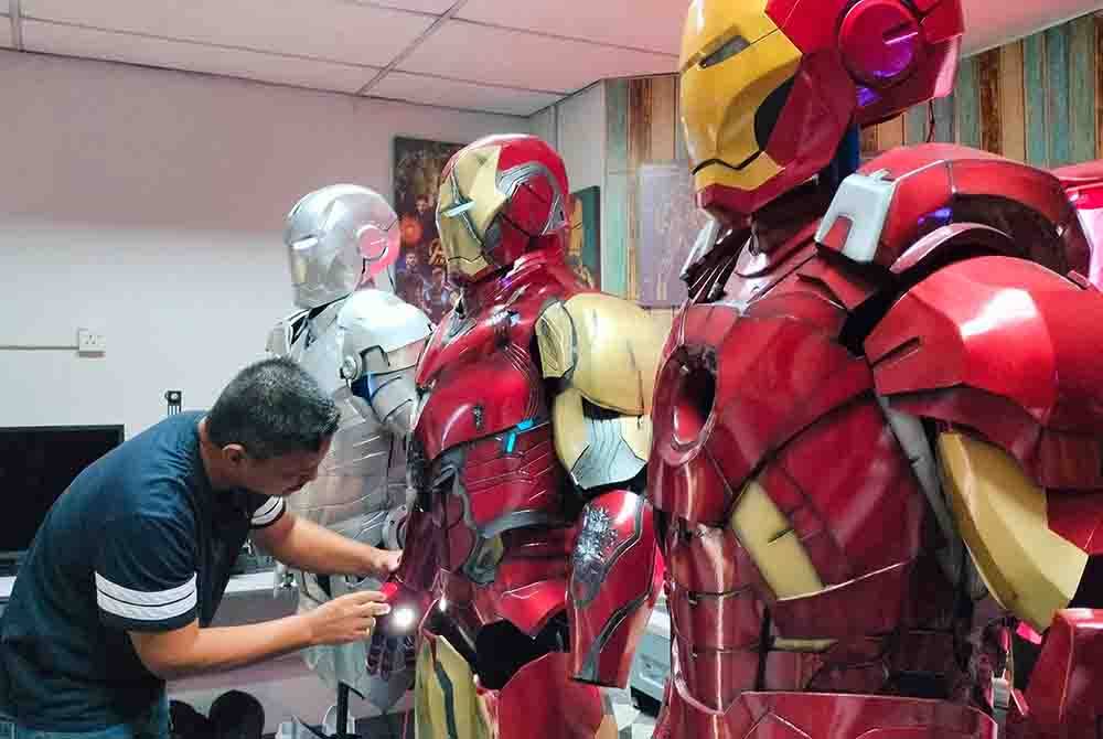 Mohd Rostam memasang tangan Ironman bagi memastikan kostum itu lengkap dan sempurna.