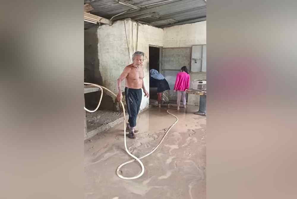 Abdullah (kiri) mencuci lumpur di rumah kedainya.