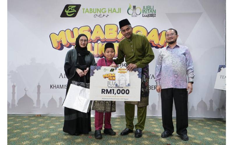 Muhammad Aqeef, 12, (dua dari kiri) menerima hadiah selepas meraih Johan Qari sempena program Musabaqah Cilik TaHa 2023 