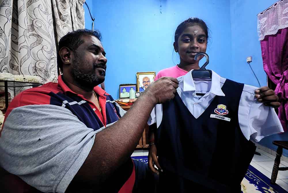 Rajheswaran memadankan baju sekolah Shivaani.