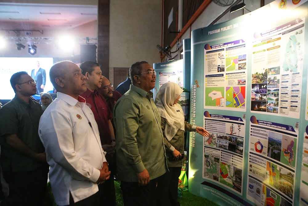 Sanusi (kanan) sedang melihat sudut pameran ketika Majlis Perasmian Program Publisiti dan Penyertaan Awam Draf Rancangan Tempatan Daerah Padang Terap di Dewan Tunku Putra pada Ahad.