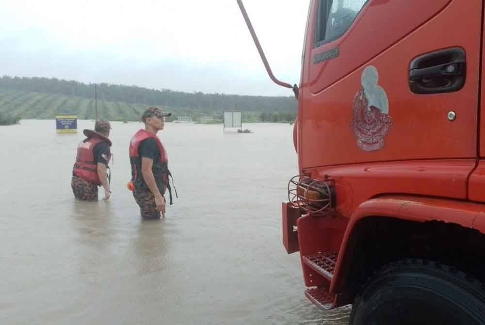Anggota bomba membantu memindahkan penduduk terjejas akibat banjir di sekitar Johor Bahru. Foto Bomba