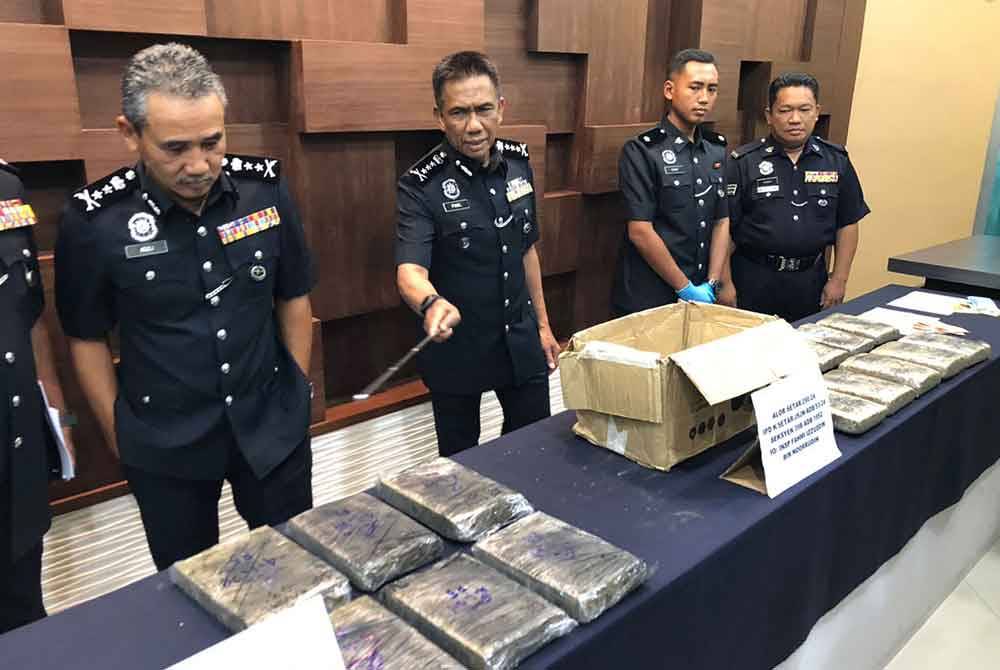 Fisol (dua dari kiri) menunjukkan ketulan ganja yang berjaya dirampas dari empat individu dalam dua serbuan berasingan di Kampung Kuala Alor, Simpang Kuala pada Khamis lalu.