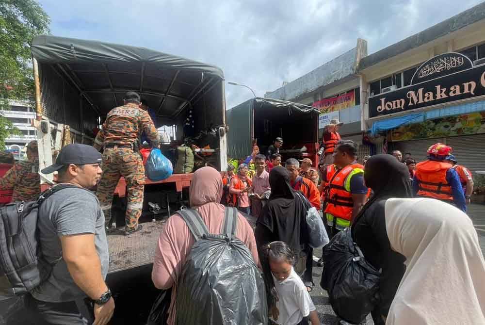 Anggota bomba menyelamatkan mangsa-mangsa banjir yang terperangkap dalam rumah sekitar kampung dan taman di bandar Kota Tinggi pada Isnin.