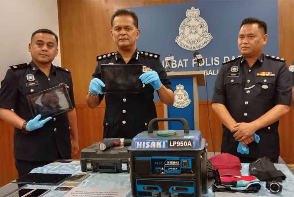 Mohd Zaidi (dua dari kiri) menunjukkan barangan yang berjaya dirampas hasil daripada aktiviti pecah rumah yang dilakukan suspek.
