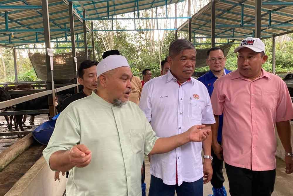 Mohamad (tengah) mendengar taklimat daripada Paizol Akman (kanan) semasa sesi lawatan ke projek pembiakan dan penternakan lembu baka wagyu di Kampung Seneng, Jelawat, Bachok.