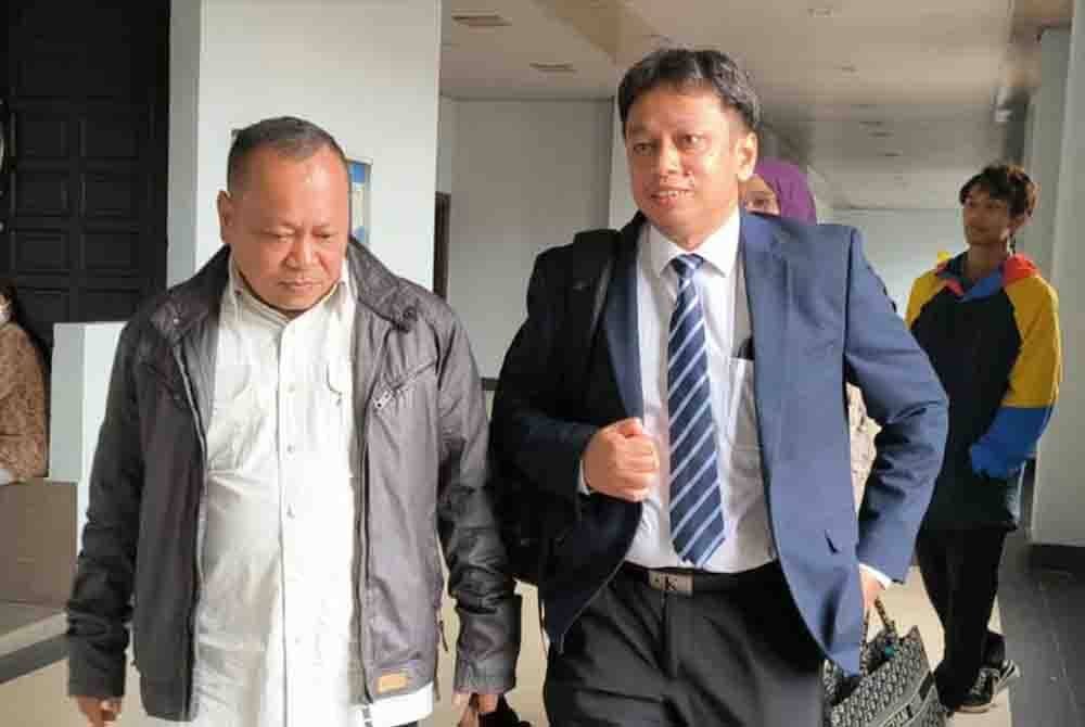 Agus Rizal (kiri) bersama peguamnya berada di Mahkamah Sesyen Kuala Lumpur pada Selasa.