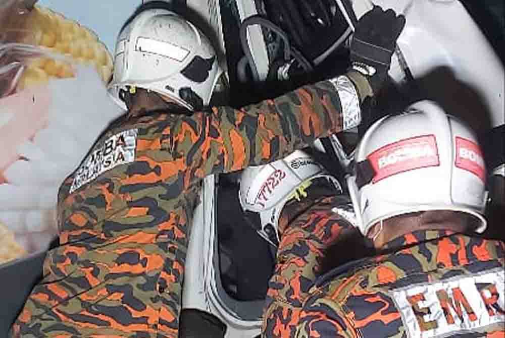 Pasukan bomba menggunakan peralatan khas bagi membawa keluar mangsa yang tersepit dalam lori. Foto ihsan Bomba Perak