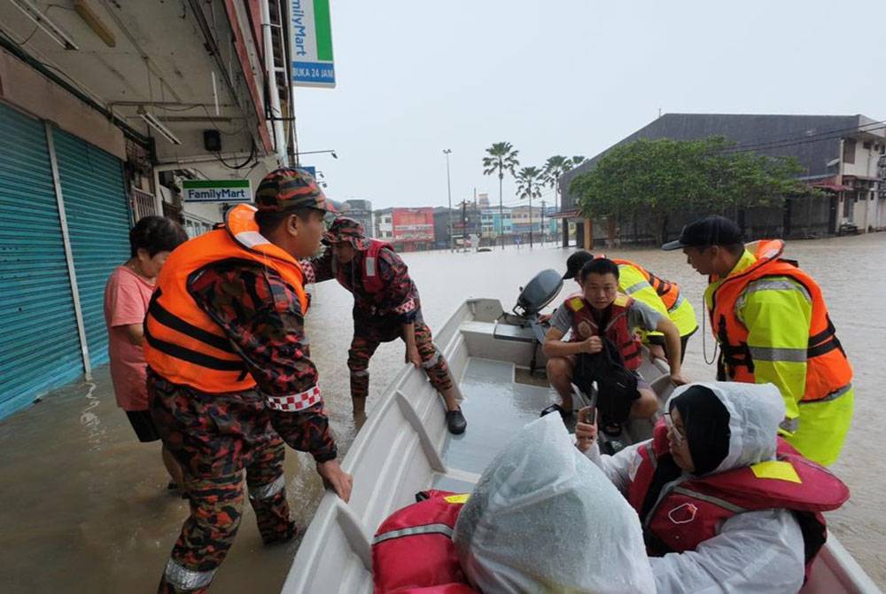Anggota penyelamat membantu penduduk berpindah ke PPS.