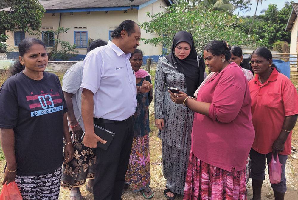 Nurul Syazwani (tiga dari kanan) dan Ananthan (dua dari kiri) mendengar permasalahan penduduk di kampung berkenaan.