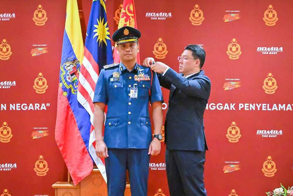 Kor Ming (kanan) memakaikan tanda pangkat kepada Nor Hisham pada Istiadat Pemakaian Tanda Pangkat Ketua Pengarah JBPM pada Selasa.